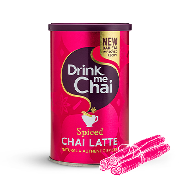 A tin container of Drink Me Chai Spiced Chai Latte with a pink label, featuring an illustration of a cup with steam and spices, alongside a stylized graphic of a cinnamon stick.